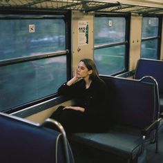 a woman sitting on a train looking out the window