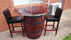 a wooden barrel table with three chairs around it