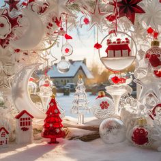 an assortment of christmas ornaments are displayed in front of a snowy landscape with houses and trees