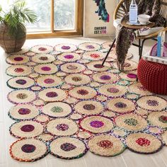 a room with a chair and rugs on the floor in front of a window