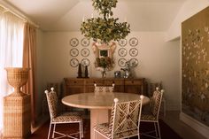 a dining room table with four chairs and a chandelier hanging from the ceiling