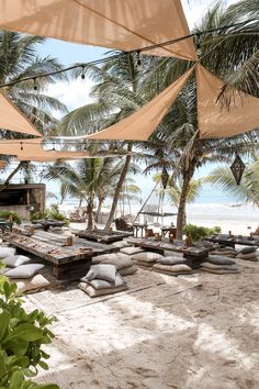 an outdoor seating area on the beach with palm trees