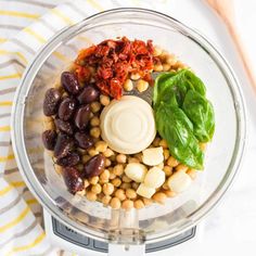 a food processor filled with beans, spinach leaves and other ingredients to make a healthy meal