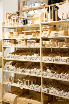 the shelves are filled with many different types of wooden items in boxes and baskets on them