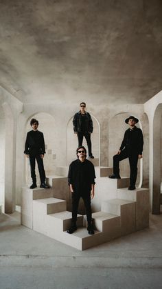 three men in black standing on some steps