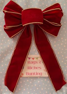 a red bow on top of a bed with the words rags and bones bunting