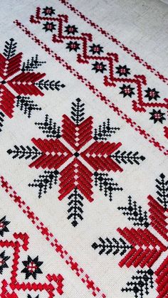 a red and black snowflake pattern on white fabric