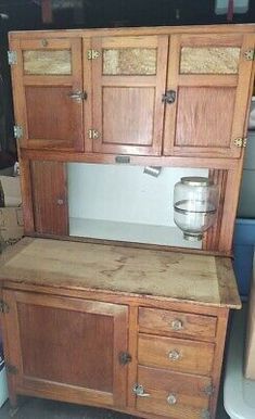 an old wooden cabinet with glass doors on it's front and side drawers in the back