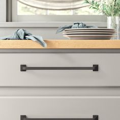 a kitchen counter with two drawers and plates on it