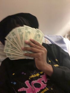 a person covering their face with money