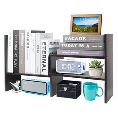 a book shelf with books, alarm clock and other items on top of it in front of a white background