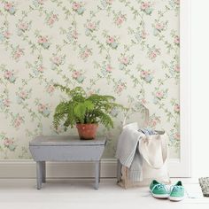 a room with a bench, potted plant and shoes on the floor next to it