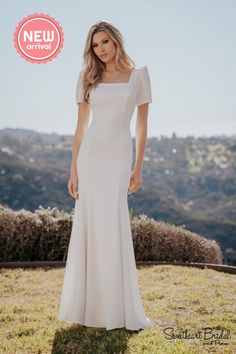 a woman in a white dress standing on top of a grass covered field