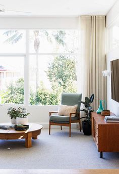 a living room filled with furniture and a flat screen tv on top of a wooden table