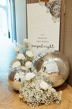 white flowers are on the floor next to two disco ball vases