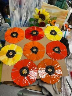 there are many flowers on the table and one is painted orange, yellow, and red