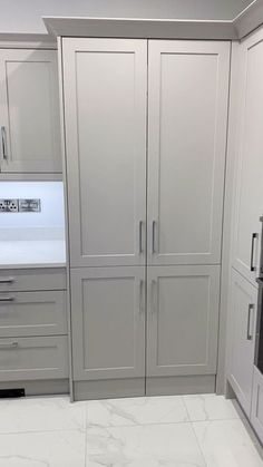 a kitchen with marble counter tops and white cabinets