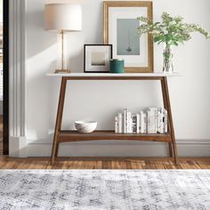 a living room with a rug, table and pictures on the wall next to it