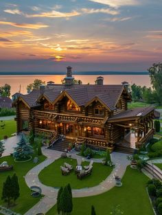 an aerial view of a log home at dusk with the sun setting in the background