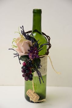 a wine bottle with some flowers in it and a tag on the side that says love