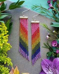 "These long, lightweight earrings are easy to wear and full of color and movement. They are hand-woven with needle and thread using a bright, shimmery rainbow of pink, red, orange, yellow, green, blue, and purple seed beads, cascading from a satin gold metal bar. These earrings measure approximately 3.75\" long x .625\" wide. The earwires are 10kt Gold-Filled and are 100% nickel-free. ** Please note: each pair of earrings is made to order and there may be slight variations from piece to piece. * Adjustable Rainbow Earrings With Tiny Beads, Rainbow Tiny Beaded Earrings For Festivals, Rainbow Earrings With Tiny Beads For Festivals, Bohemian Rainbow Earrings With Dangling Beads, Rainbow Festival Earrings With Tiny Beads, Rainbow Tiny Beads Earrings For Festival, Bohemian Rainbow Earrings With Tiny Beads, Bohemian Rainbow Beaded Earrings With Ear Wire, Rainbow Beaded Bohemian Earrings