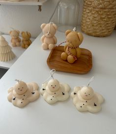 some little teddy bears sitting on top of a white table next to other small figurines