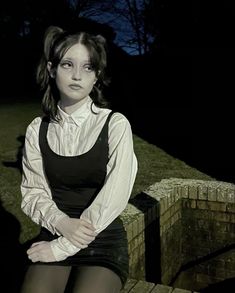 a woman sitting on top of a wooden bench