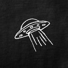 a black t - shirt with a white drawing of a flying saucer on it