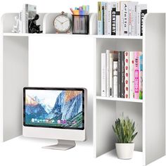 a computer monitor sitting on top of a white book shelf next to a potted plant