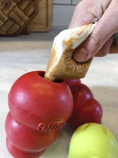 a person is cutting tomatoes with a knife on top of them and text overlay reads how to stuff a kong without the mess 4 more kong hacks