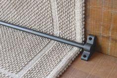 a close up of a metal handle on a wooden floor next to a white blanket