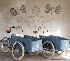 two old fashioned bicycles parked next to each other in front of a wall with drawings on it