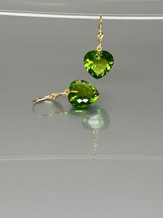 Gorgeous sparkly peridot heart earrings.The Faceted heart shape drops are flawless and have a beautiful clear green color. The drops attached to secure 14k gold-filled lever backs. The earrings are elegant and have a lux look. A truly gorgeous pair of earrings. *AAA+ Faceted peridot hearts *The dimension of stones is about: 15mm *Metal: 14k gold filled *Earrings drop length (ear wires including the stones): 32 mm/ 1.3 inch Solid gold, 14K gold-filled, sterling silver, and gemstones are my materi Heart Charm Earrings In Fine Jewelry Style, Elegant Green Earrings With Heart Charm, Elegant Green Heart Earrings For Gift, Elegant Gemstone Heart Drop Earrings, Heart-shaped May Birthstone Earrings For Anniversary, Heart Shaped May Birthstone Earrings For Anniversary, Heart-shaped Gemstone Earrings As Gift, Elegant Heart-shaped Gemstone Earrings, Elegant Green Heart Cut Earrings