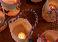 several candles are lit in small containers on the floor next to some string wrapped candle holders