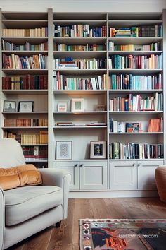 a white chair sitting in front of a book shelf filled with lots of different books