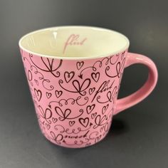 a pink coffee cup with hearts on it