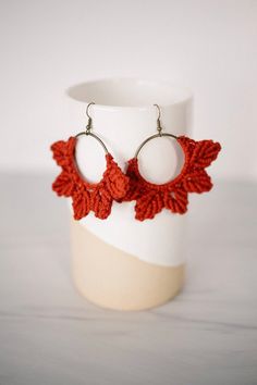 red crochet earrings on a white cup