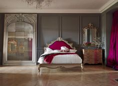 a bedroom with a bed, dresser and chandelier in the middle of it