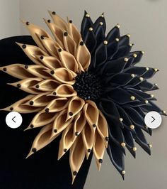 a black and gold flower on top of a mannequin's head