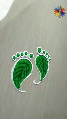 a pair of feet with green leaves painted on them