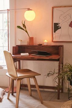 a wooden chair sitting in front of a desk with a lamp on top of it