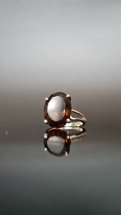 Step back to the glamorous 1980s with this exquisite vintage sterling silver ring. Crafted in sterling silver, this ring boasts a beautiful smoky quartz gemstone that captures the essence of the era's bold and luxurious style. The centrepiece of this ring is a rich, earthy smoky quartz, elegantly cut into a diamond shape. The smoky quartz exudes a warm, deep brown hue that reflects the sophisticated and mysterious ambience of the 1980s. The stone is securely cradled in a prong setting, featuring Classic Brown Hallmarked Rings, Classic Brown Gemstone Rings, Classic Brown Rings With Polished Finish, Vintage Oval Topaz Ring With Polished Finish, Formal Brown Gemstone Ring, Classic Oval Brown Ring, Classic Smoky Quartz Rings For Formal Occasions, Formal Brown Rings With Polished Finish, Classic Smoky Quartz Jewelry For Formal Occasions