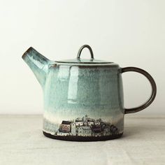 a tea pot with a handle on top of a table