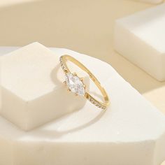 The Marquise East West Ring has a minimalist design as an elegant ring. Its plainness of glamorous modesty embellished with glittering stones will fascinate people around you. It is perfect for everyday use and ring stacking. - Decorated with handset white cubic zirconia stone on 14k solid gold - Made in 14k solid gold - Band Width: 1.45 mm \ 0.057 inches- Ring Width: 9.46x5.79 mm \ 0.372x0.227 inches- Thickness: 1.23 mm \ 0.048 inches - This product comes with iconic Norm Jewels gift box Formal Stackable Crystal Ring, Stackable Crystal Ring For Formal Occasions, Elegant Sparkling Stackable Promise Rings, Classic Gold Sparkling Rings, Minimalist Crystal Ring With Diamond Accents For Promise, Elegant Sparkling Crystal Promise Ring, Diamond Open Promise Ring, Sparkling Open Diamond Ring, Dainty Sparkling Promise Ring