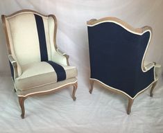 two chairs sitting next to each other in front of a white backdrop with blue trim