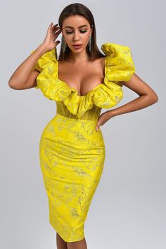 a woman in a yellow dress posing for the camera