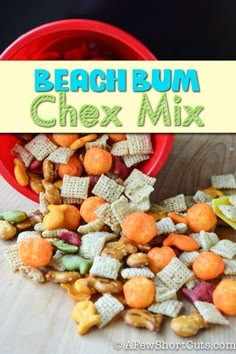 a red bowl filled with chex mix on top of a wooden table