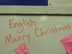 an english merry christmas sign with pink origami snowflakes and the words'english merry christmas'written on it