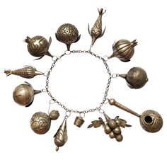 a silver bracelet with various metal objects on it's chain, all in different shapes and sizes