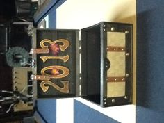 an open trunk sitting on top of a blue floor next to a clock and wreath